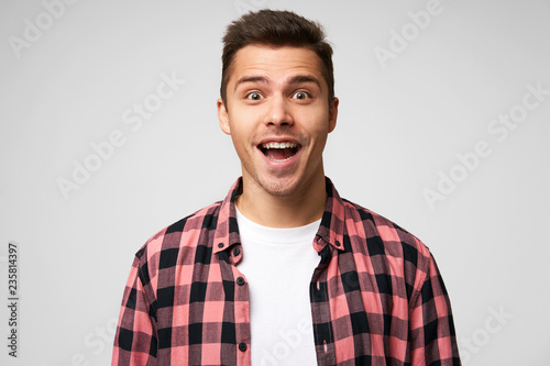 Portrait of a man by good fortune, luckily gets a prize. Male receives great offer, hears some incredible news, isolated over white background. photo