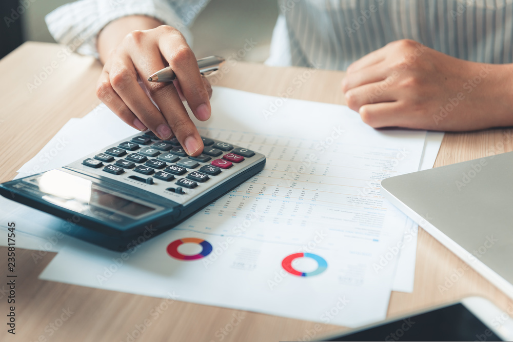 Close up portrait of businesswoman accountant using calculator and laptop for matching financial data saving in office room, Business financial, tax, accounting concept Close up portrait of businesswoman accountant using calculator and laptop for matching financial data saving in office room, Business financial, tax, accounting concept