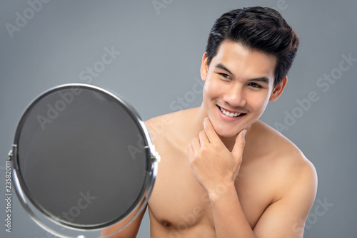 Photos Asian male model confidently looking himself in the mirror