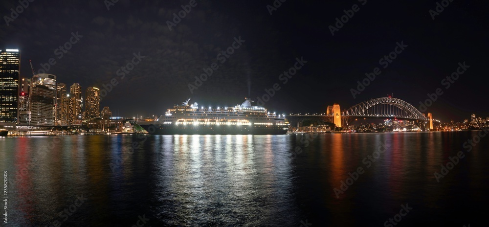 Panorama of Night cityscape : Wonderful Night view of colourful city and cruise ship near Harbor Bridge at Sydney, Australia. View at Sydney Harbour at night.