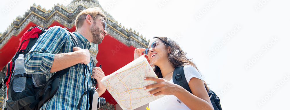 Obraz premium Tourist couple backpackers traveling in Thai temple on summer vacations in Bangkok