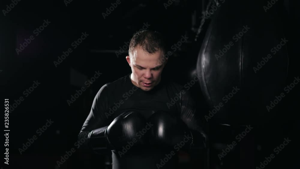 Portrait man in boxing gloves. Young Boxer fighter over black background. Boxing man ready to fight. Boxing, workout, muscle, strength, power - the concept of strength training and boxing Portrait man in boxing gloves. Young Boxer fighter over black background. Boxing man ready to fight. Boxing, workout, muscle, strength, power - the concept of strength training and boxing