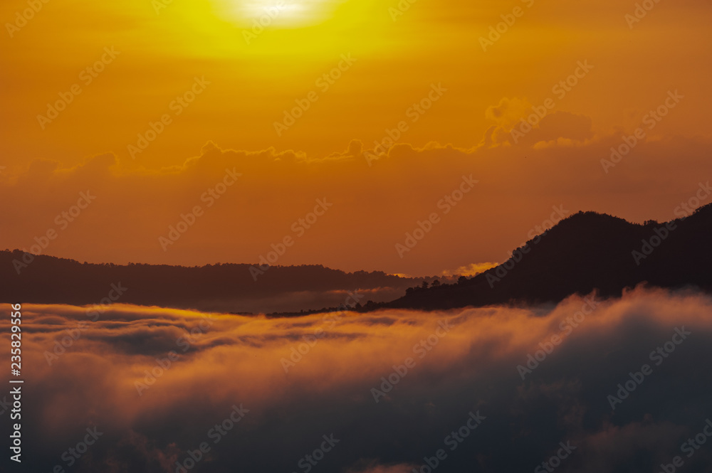 Fototapeta premium Beautiful dramatic sunset in the mountains. Landscape lot of fog Phu Thok Mountain at Chiang Khan ,Loei Province in Thailand.