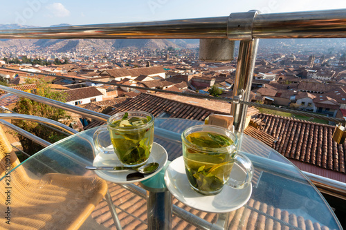 Enjoying cups of coca tea with view of Cusco city in Peru photo