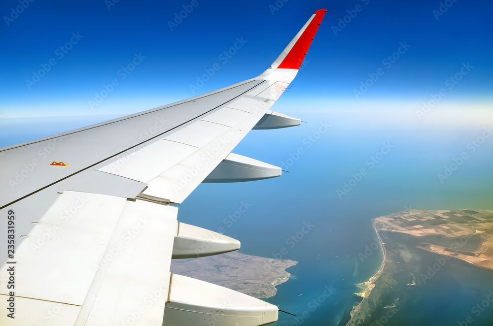 Obraz premium passenger airplane window seat wing view on black sea kerch strait scenery overlooking azov sea air travel aerial satellite panoramic transportation landscape background