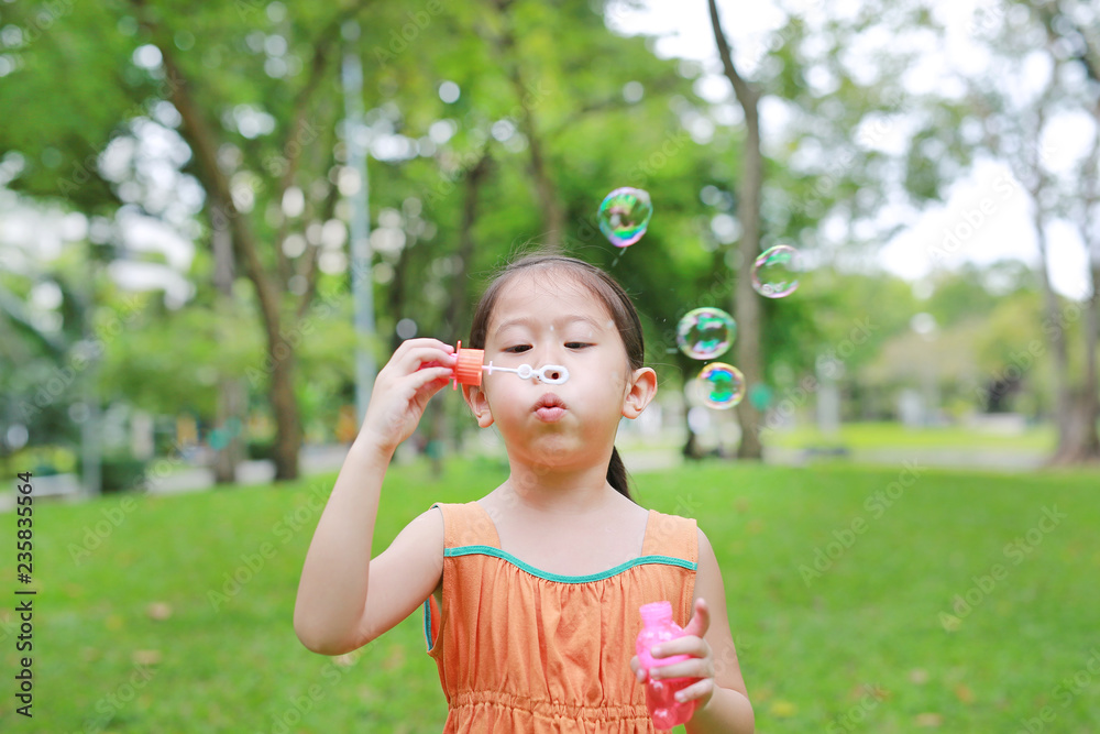 Cute Asian little girl playing bubble in summer park. Cute Asian little girl playing bubble in summer park.