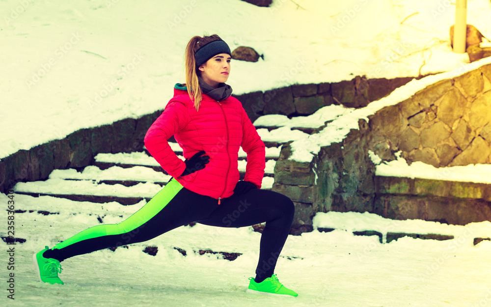Obraz premium Woman wearing sportswear exercising outside during winter