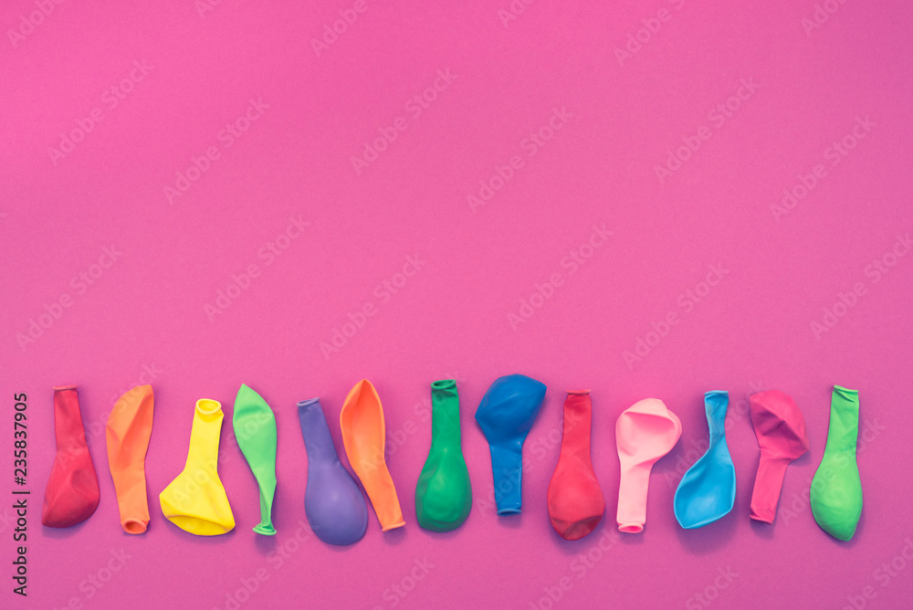 Set of colored balloons on pink background Flat lay top view