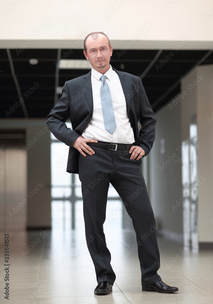 smiling confident businessman on background of office. smiling confident businessman on background of office.