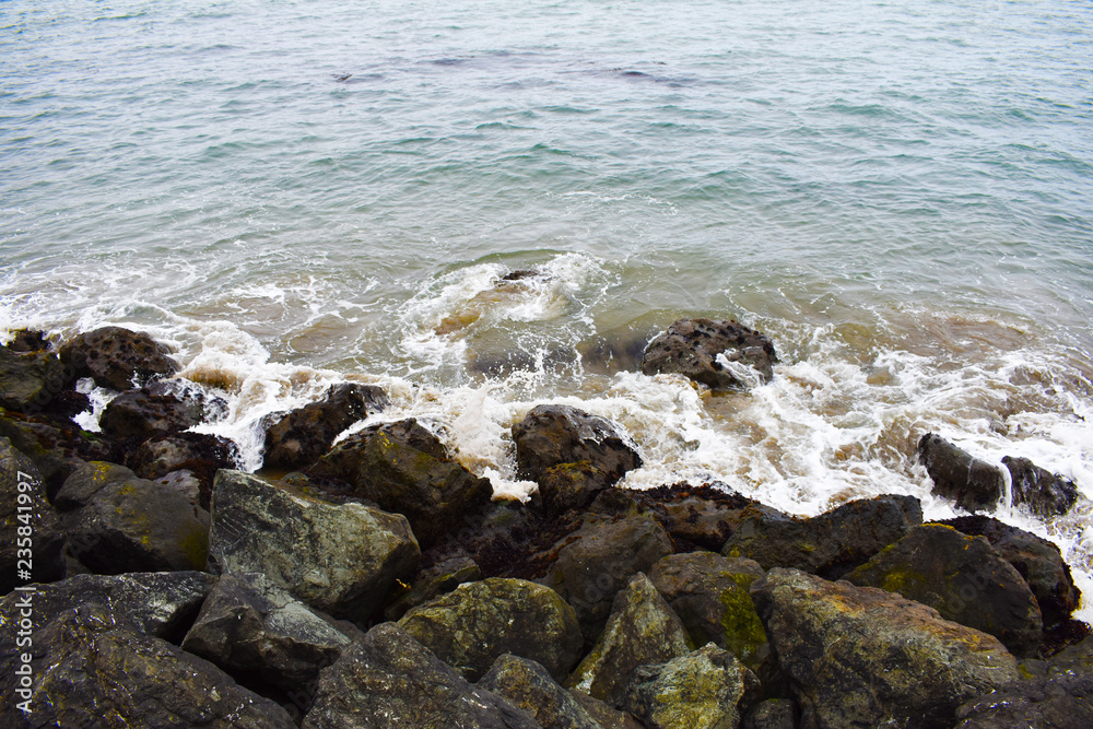 Splendorous waves of water crashing on rocks in the beach