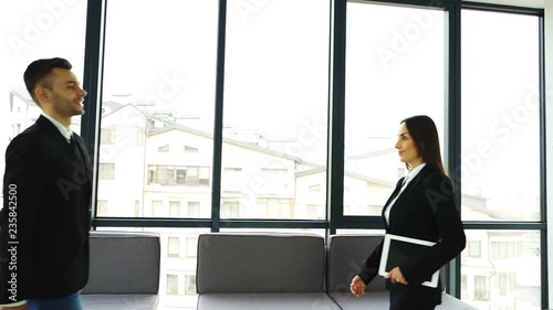 Meeting of business partners. Man and woman shake hands and smiles. Slow motion