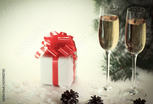 two glasses with champagne and cones on the Christmas background