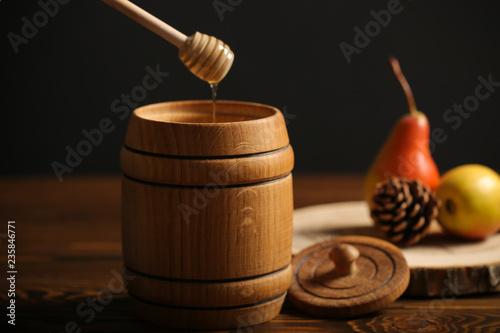 мёд в бочке свежий урожай и орехи разные стоят на столе