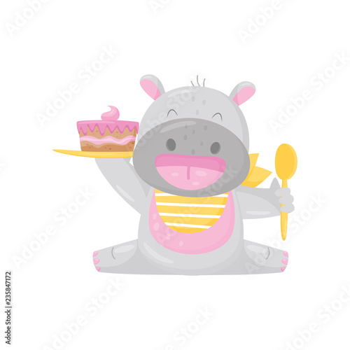 Cute smiling hippo in a bib eating cake with spoon, lovely behemoth animal cartoon character vector Illustration