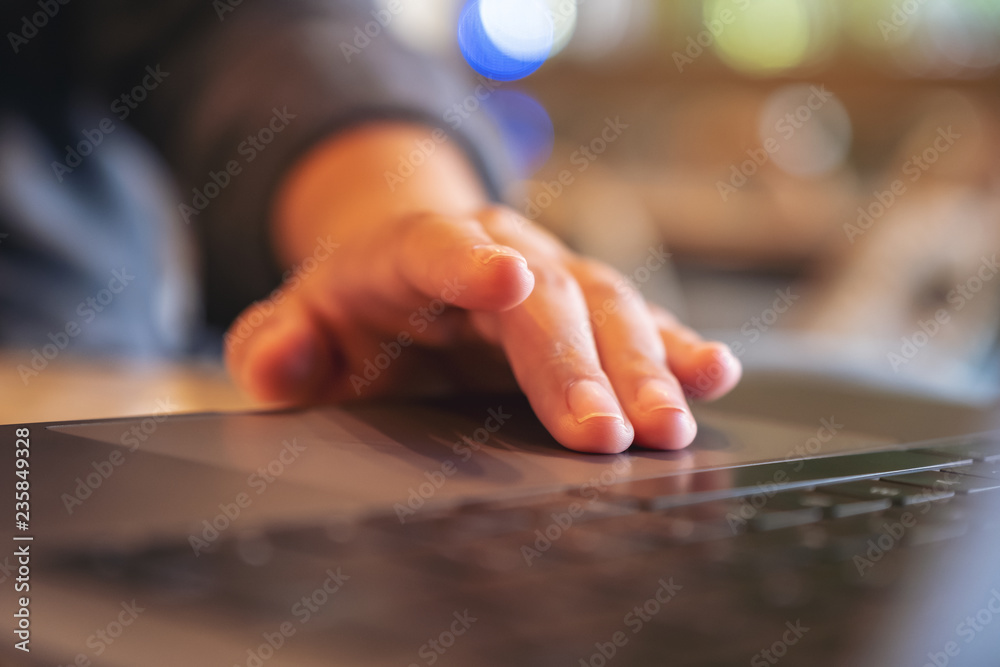 Closeup image of hands using and touching on laptop touchpad on wooden table Closeup image of hands using and touching on laptop touchpad on wooden table