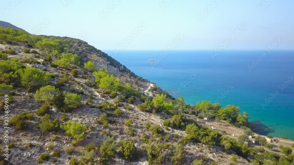 Flying over green mountainous coast near sea Flying over green mountainous coast near sea