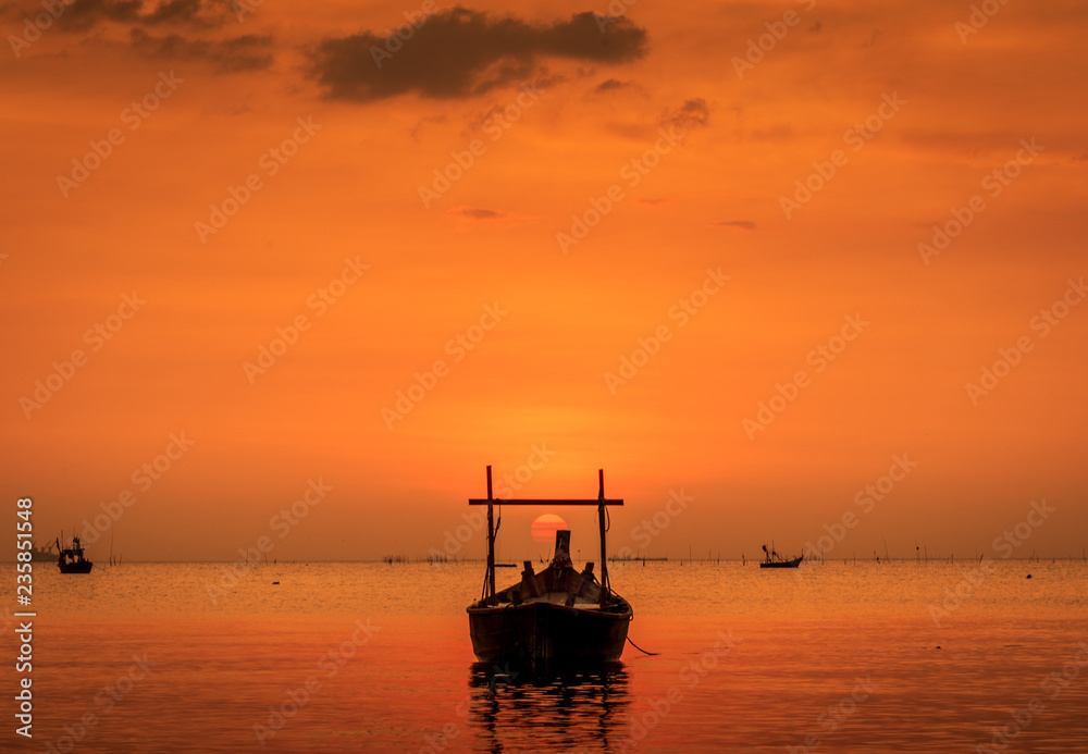 Landscape on the beach with wooden fishing boat and sunset twilight.