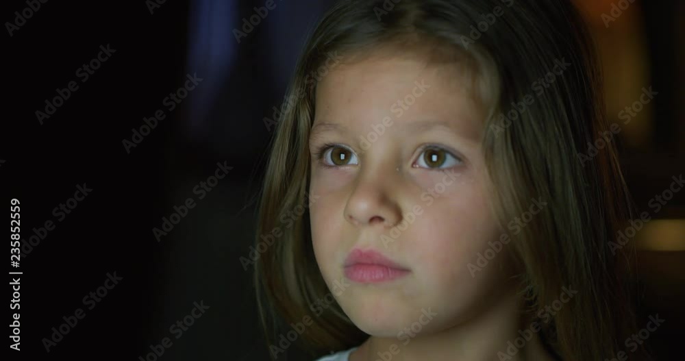 Portrait of a beautiful blond little girl (kid) while watching the TV. Portrait of a beautiful blond little girl (kid) while watching the TV.