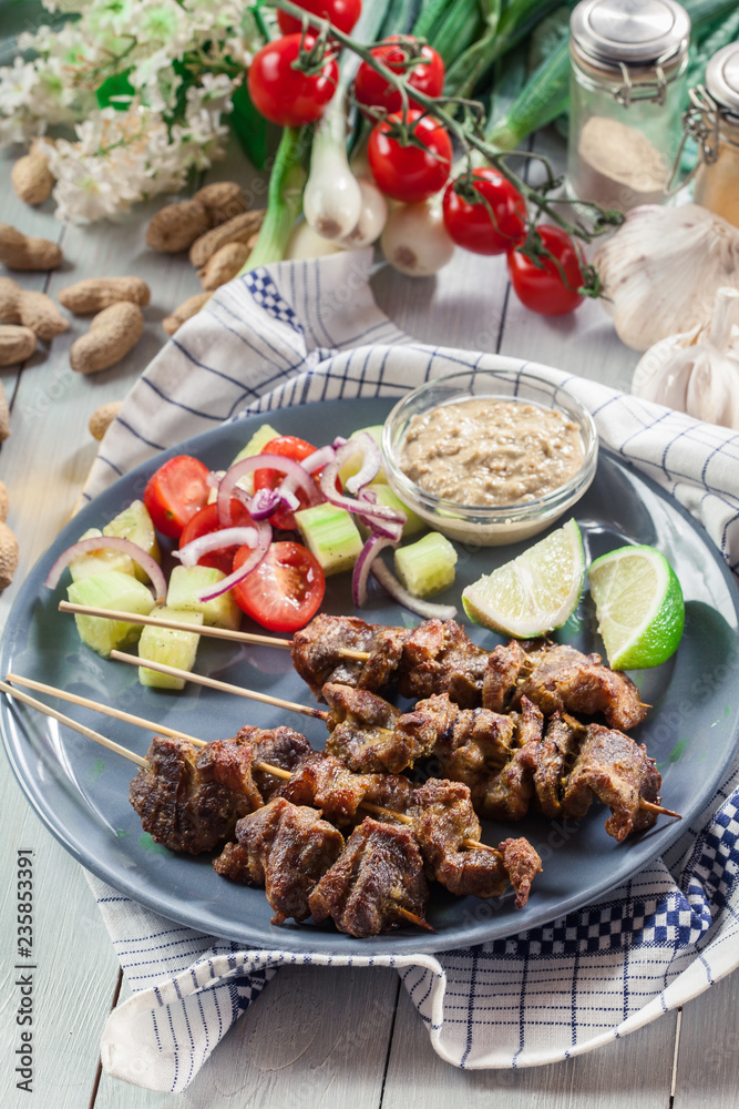 Traditional pork satay with peanut sauce and vegetables