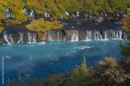 Barnafoss waterfall decorated with autumn trees