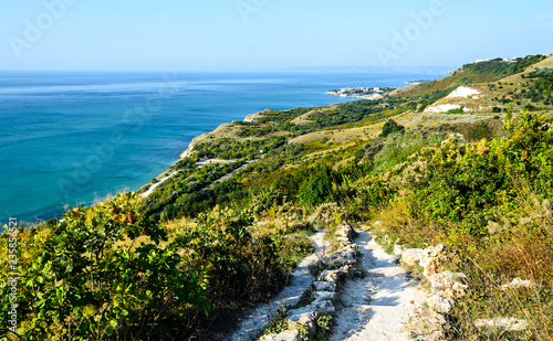 Green Thracian cliffs near blue clear water of Black Sea, rocky path seaview photo