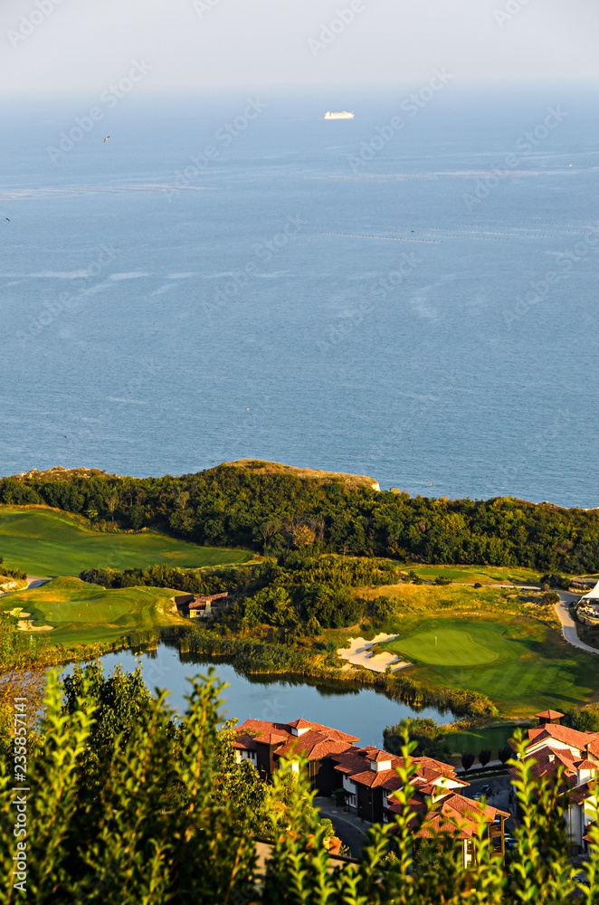 Green Thracian cliffs near blue clear water of Black Sea, lake golf terrain