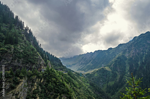 The Transfagarasan road in Fagaras mountains, Carpathians with green grass and rocks, peaks in the clouds