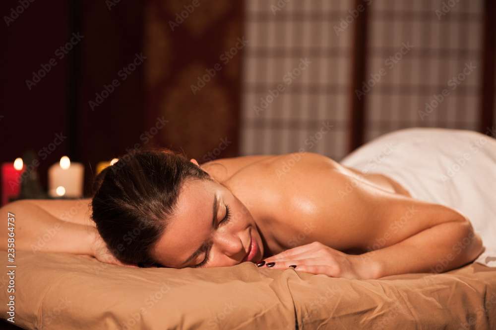 Attractive woman lying on massage table at spa center, copy space. Young female client waiting for her relaxing full body massage, spending day at pamper salon. Recreation, health, relaxation concept Attractive woman lying on massage table at spa center, copy space. Young female client waiting for her relaxing full body massage, spending day at pamper salon. Recreation, health, relaxation concept