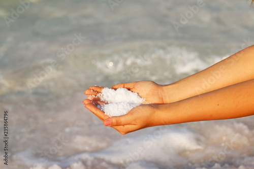 girl's hands against the background of sea and salt, dead sea