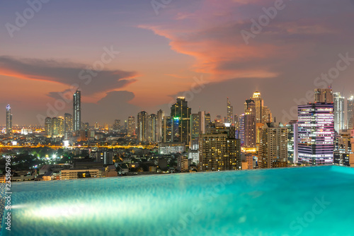 Bangkok city at sunset with swimming pool in foreground. Traveling to Thailand.