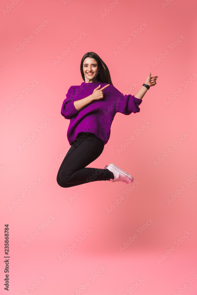 Beautiful young emotional woman posing isolated over pink background showing copyspace.