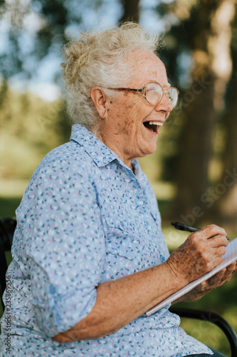 Senior woman writing down her memories into a notebook