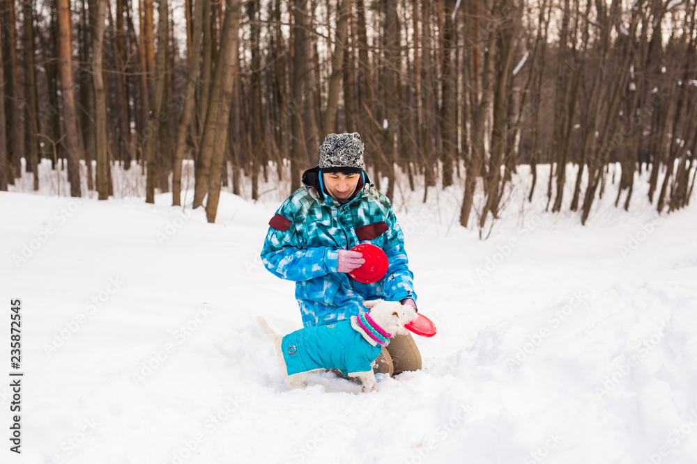 Jack Russell Terrier dog with owner woman playing in the winter outdoors. Jack Russell Terrier dog with owner woman playing in the winter outdoors.