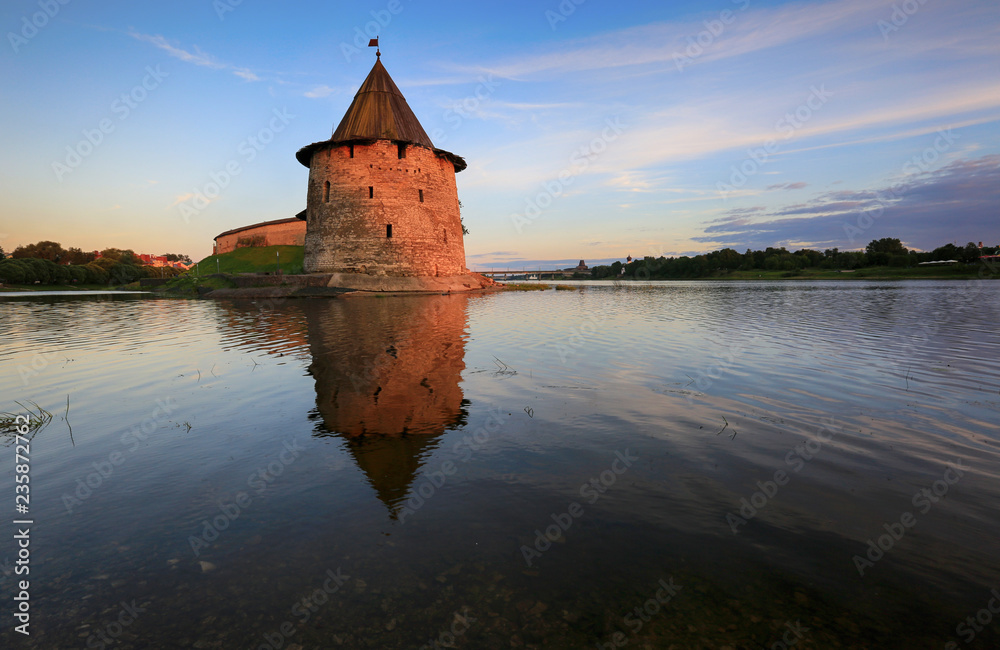 Ancient tower of the Pskov Kremlin with reflection in the river in the evening, Pskov, Russia
