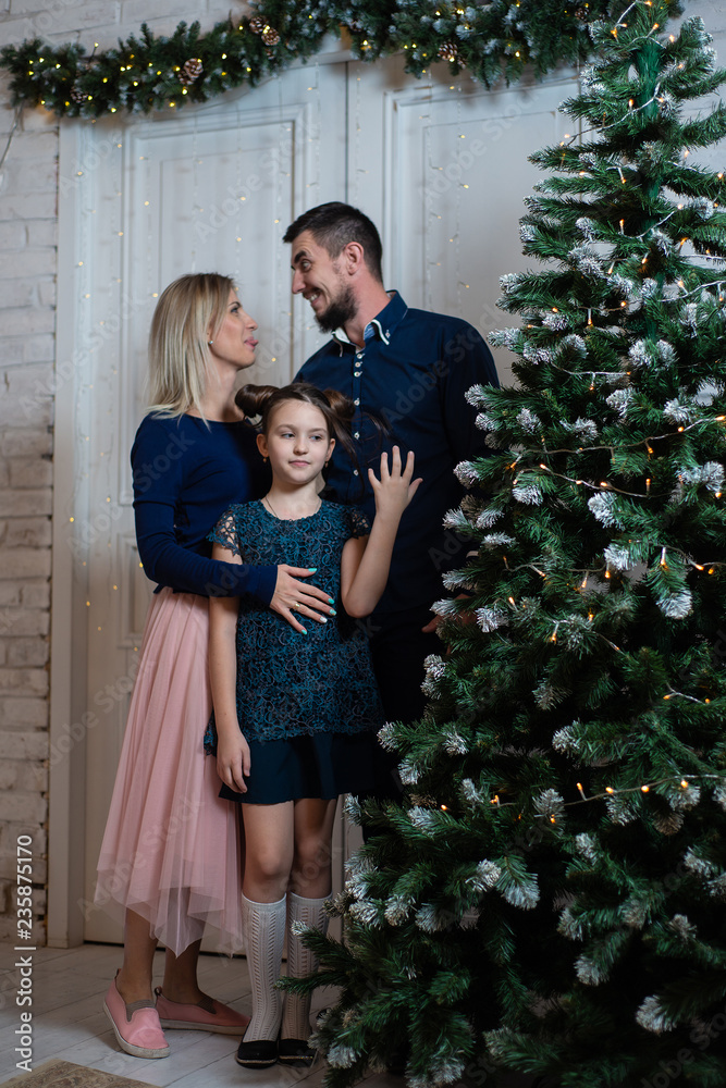Fototapeta premium Christmas photo of happy family with gift boxes on background of decorated Christmas tree. Family celebrates New year