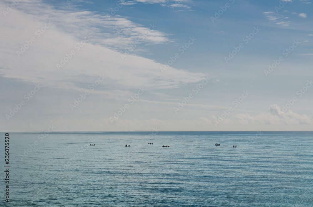 fishing boats far into the sea under the sky