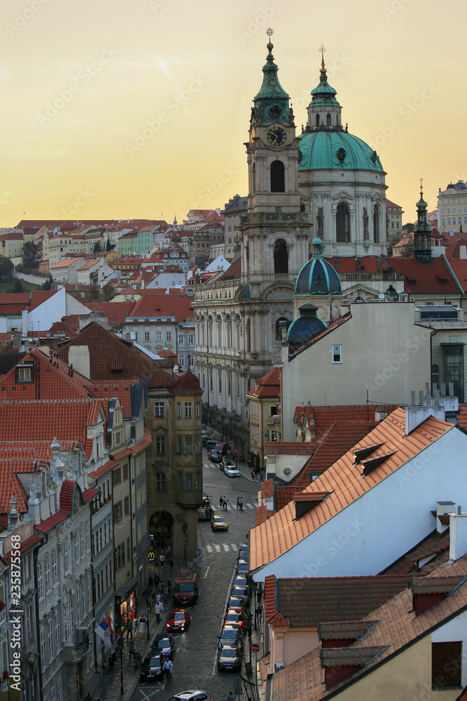 Obraz premium Prague, Czech Republic, September 19, 2018. Beautiful evening view from above on the city, the red roofs of houses in Mala Strana and the church of St. Nicholas