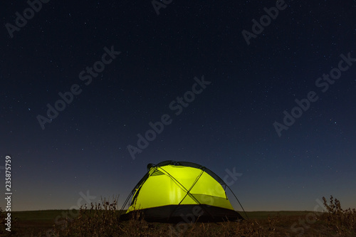 Night sky with stars over the tourist tent. The landscape was photographed on a long exposure. © olgapkurguzova