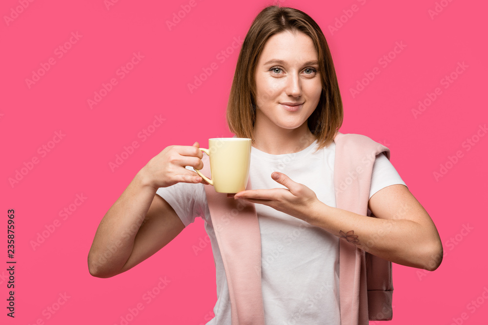 beautiful young woman holding mug and smiling at camera isolated on pink beautiful young woman holding mug and smiling at camera isolated on pink