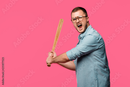 Photography aggressive young man in eyeglasses holding baseball bat and screaming at camera