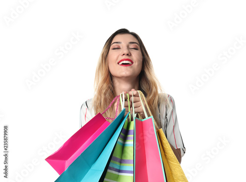 Happy young woman with shopping bags on white background