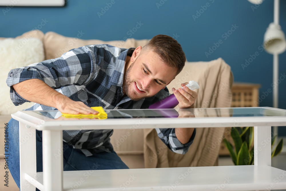 Obraz premium Young man cleaning flat