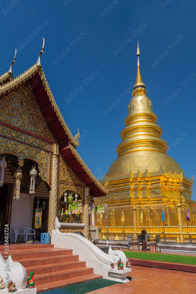 Naklejka premium Wat Phra That Hariphunchai The province Lampoon of Thailand. There is a statue of Kruba Srichai in the temple.The temple has a golden pagoda. And green lawns. And the beautiful temple gazebo.