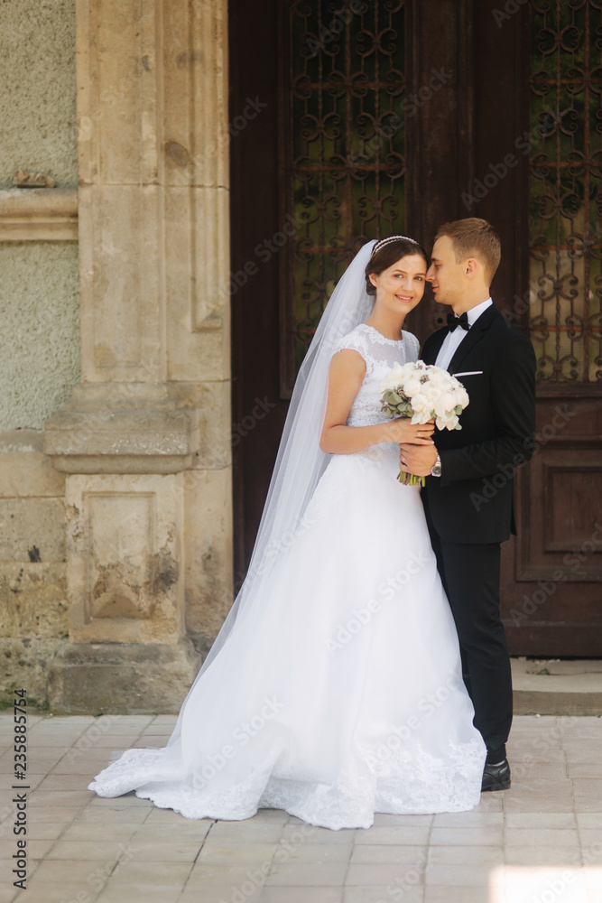 Happy newlyweds spend time together in their wedding day. Groom and bride