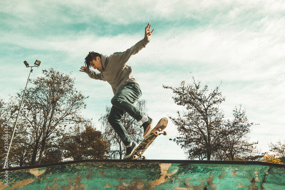 Guy practicing skateboarding and doing tricks in a skatepark. Skateboarder jumping Guy practicing skateboarding and doing tricks in a skatepark. Skateboarder jumping