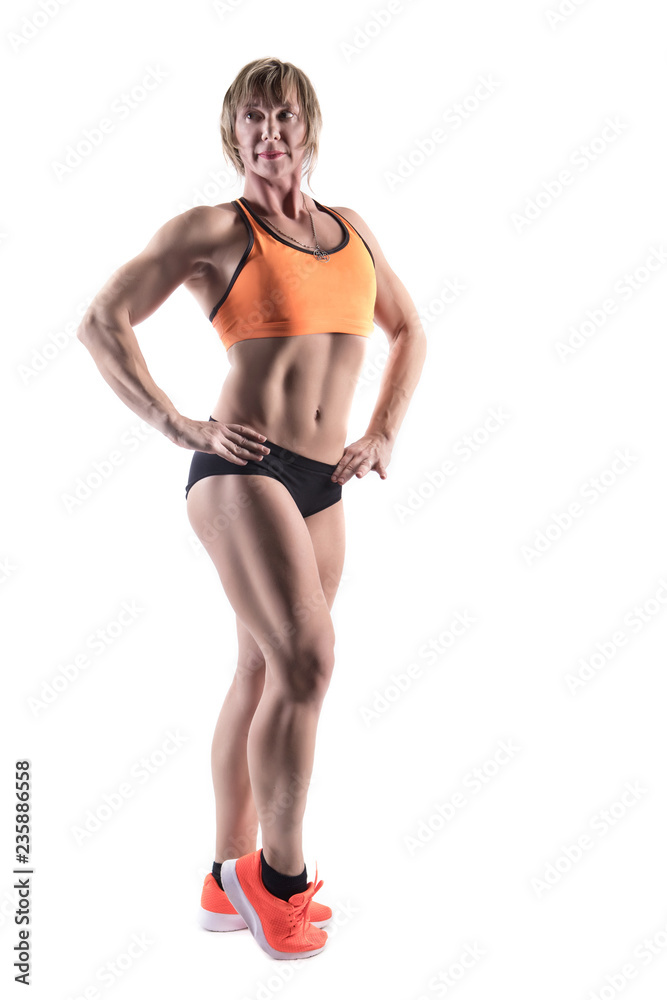 Cute athletic girl posing in the studio isolated on white background. Young woman bodybuilder or fitness coach wearing sportswear tracksuit Cute athletic girl posing in the studio isolated on white background. Young woman bodybuilder or fitness coach wearing sportswear tracksuit