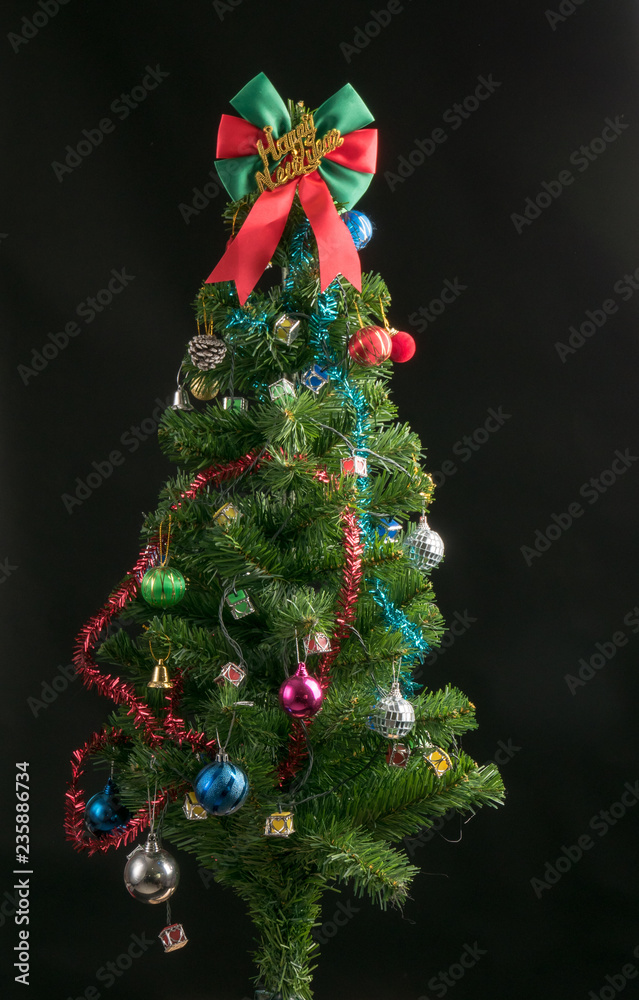 Obraz premium Decorated Christmas tree isolated on black background studio shot for family, giving, season, Christmas, holiday, new year, travel, Christian and gathering concept