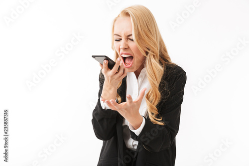 Screaming displeased business woman posing isolated over white background wall talking by phone.