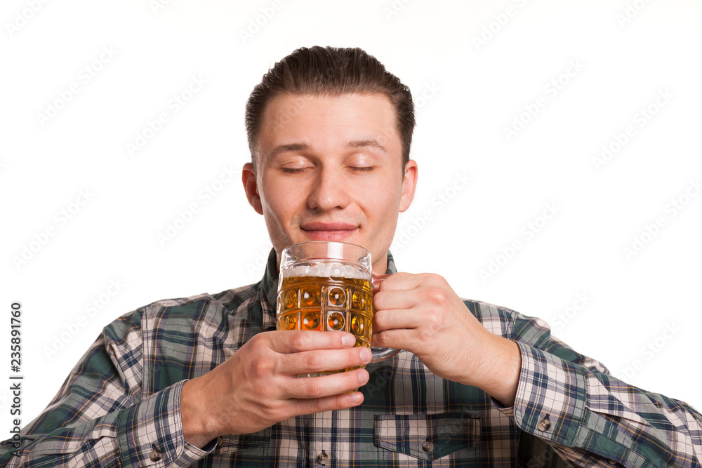 Studio portrait of a young handsome man smiling with his eyes closed in pleasure, smelling delicious beer isolated on white. Joyful man celebrating Oktoberfest. Restaurant, bar or pub concept Studio portrait of a young handsome man smiling with his eyes closed in pleasure, smelling delicious beer isolated on white. Joyful man celebrating Oktoberfest. Restaurant, bar or pub concept