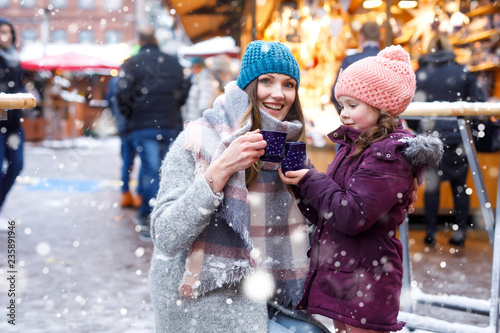 Photography Happy kid girl and young beautiful woman with cup of steaming hot chocolate and mulled wine